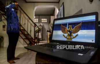 Seorang Aparatur Sipil Negara (ASN) mengikuti upacara peringatan Hari Kelahiran Pancasila melalui siaran langsung dari televisi di rumahnya di Bogor, Jawa Barat, Selasa (1/6). Upacara peringatan Hari Kelahiran Pancasila dilaksanakan secara virtual karena pandemi COVID-19 belum mereda dan para ASN diimbau melaksanakan upacara di rumah masing-masing. 