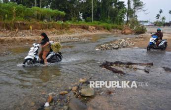 Jembatan Masih Rusak, Warga Lintasi Jalur Sungai Batang Belimbing dengan Motor