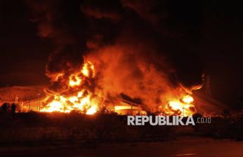 Kobaran api terlihat di fasilitas penyimpanan minyak Iran yang terbakar akibat serangan Israel di Teheran, Iran, Ahad (15/6/2025).
