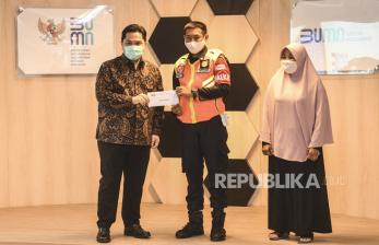 Menteri BUMN Erick Thohir (kiri) memberikan bantuan secara simbolis kepada Petugas Satuan Pengamanan KAI dan KCI Egi Sandi Saputra (tengah) sebagai bentuk Apresiasi Kejujuran Kementerian BUMN di kantor Kementerian BUMN, Jakarta, Senin (13/7/2020). Kementerian BUMN memberikan apresiasi berupa uang secara langsung atas kejujuran kedua pegawai yang mengembalikan kantong plastik hitam berisi uang tunai Rp500 juta saat bertugas menjaga keamanan dan kebersihan di salah satu gerbong KRL tujuan Jakarta - Bogor, Senin (6/7) lalu.