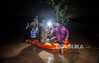 In Picture: Di Bawah Sinar Lampu, Warga Korban Banjir Dievakuasi Gunakan Perahu karet