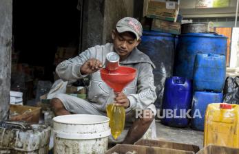 Pekerja menuangkan minyak goreng curah ke dalam plastik di salah satu kios sembako di Jalan Cipaera, Lengkong, Kota Bandung, Rabu (16/3/2022). Pemerintah memutuskan hanya mengatur harga minyak goreng curah sebesar Rp 14 ribu per liter dengan bantuan subsidi. Sementara, harga minyak goreng kemasan sederhana dan premium dilepas sesuai harga pasar.
