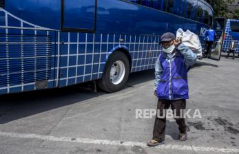 Seorang pelaku transportasi darat berjalan membawa sembako usai kegiatan pemberian bantuan sosial (bansos) bagi pelaku usaha transportasi darat. 