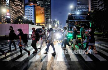 Pekerja melintas di pelican crossing kawasan Sudirman, Jakarta, Selasa (17/5/2022). Pemerintah melalui Presiden Joko Widodo melonggarkan kebijakan aturan terkait pemakaian masker yakni memperbolehkan tidak mengenakan masker di luar ruangan apabila tidak dalam kondisi kerumunan, hal tersebut menyusul kondisi pandemi Covid-19 di Indonesia saat ini terkendali. Republika/Thoudy Badai