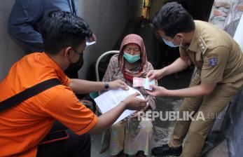 Petugas Pos Indonesia bersama petugas kelurahan menyalurkan Bantuan Langsung Tunai (BLT) subsidi minyak goreng kepada warga di Surabaya, Jawa Timur, Selasa (19/4/2022). Penyaluran BLT subsidi minyak goreng dan bantuan pangan non tunai (BPNT) senilai Rp500 ribu yang diberikan secara langsung ke rumah tersebut menyasar keluarga penerima manfaat (PKM) dengan harapan dapat membantu perekonomian mereka . 