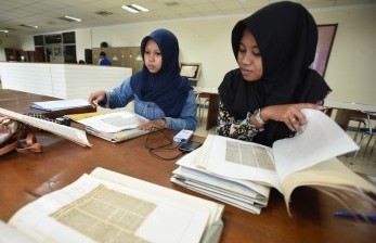 Dua mahasiswa menyadur kliping untuk bahan skripsi (ilustrasi). UI sebut akan butuh penyesuaian untuk menerapkan kelulusan tanpa skripsi.