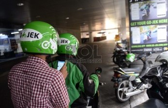Layanan ojek motor berbasis aplikasi, Gojek, membawa penumpangnya.