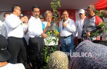 Menteri Pertanian Andi Amran Sulaiman (kedua kiri) memberikan bibit pohon jeruk kepada warga dalam rangka launching Pangan Murah Berkualitas melalui Toko Tani Indonesia di CFD Dago, Kota Bandung, Ahad (15/5). (foto : Dede Lukman Hakim)