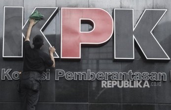 Pekerja membersihkan logo Komisi Pemberantasan Korupsi (KPK).