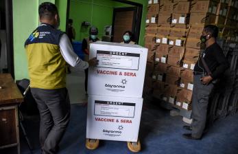 Petugas membawa kardus berisi vaksin Covid-19 Sinovac ke dalam ruang pendingin saat proses pendistribusian di Instalasi Farmasi Dinas Kesehatan Kota Bandung, Jalan Supratman, Kota Bandung.