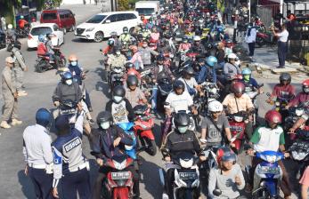 Petugas mengatur arus lalu lintas di Jalan Urip Sumoharjo saat dilakukan seleksi pengendara yang akan memasuki wilayah di Kota Madiun, Jawa Timur, Kamis (2/4/2020). Petugas menolak pengendara yang bukan warga kota Madiun memasuki wilayah tersebut yang dimaksudkan untuk mengurangi pergerakan masyarakat dari luar daerah di wilayah itu untuk mencegah penyebaran COVID-19 atau virus Corona.