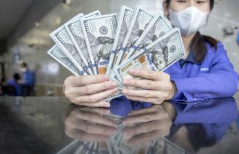 Petugas menunjukan uang pecahan dolar AS di gerai penukaran mata uang asing VIP (Valuta Inti Prima) Money Changer, Jakarta, Selasa (4/10/2022). Nilai tukar rupiah kembali menembus level Rp15.300 pada perdagangan Selasa (4/10) siang, dimana sentimen yang mempengaruhi pergerakan rupiah adalah mulai melandainya nilai dolar AS. 