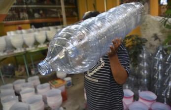 Petugas Penanganan Prasarana dan Sarana Umum (PPSU) mengangkat limbah galon plastik di Bank Sampah Berkah (BSB) Kelurahan Tugu Selatan, Koja, Jakarta Utara, Jumat (29/7/2022). Menurut petugas, limbah galon berukuran 15 liter yang telah didaur ulang menjadi pot tanaman tersebut dijual dengan harga Rp15 ribu hingga Rp30 ribu. 