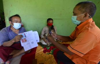 Petugas PT Pos Indonesia mendatangi rumah warga kurang mampu saat penyaluran Bantuan Sosial Tunai (BST).