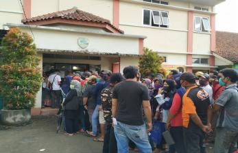 Ratusan warga mengantre untuk mendapatkan bansos dari Kemensos berupa uang tunai Rp 600 ribu di Kantor Kelurahan Karsamenak, Kecamatan Kawalu, Kota Tasikmalaya, Selasa (19/5). Warga mengantre tanpa menghiraukan protokol kesehatan physical distancing. 
