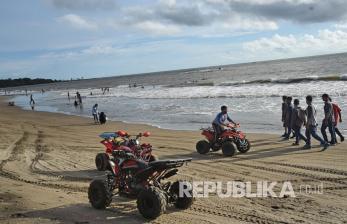 Sejumlah wisatawan memanfaatkan waktu usai berlebaran dengan rekreasi di Pantai Sambolo Anyer, Serang, Banten, Selasa (26/5/2020). Meski Pemda setempat telah menutup semua tempat wisata hingga 3 Juni 2020 untuk mencegah sebaran COVID-19 namun sejumlah pengelola wisata pantai di kawasan Anyer dan Carita tetap menerima pengunjung walau tak seramai libur lebaran tahun lalu. 
