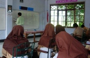 Seorang guru sedang mengajar di madrasah (ilustrasi). Anggota Komisi VIII DPR mengatakan  isu penghapusan madrasah dari dalam sistem pendidikan nasional (Sisdiknas) adalah hoaks atau kabar bohong.