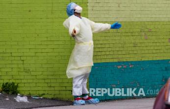 Seorang petugas medis Elmhurst Hospital Center usai keluar dari ruang gawat darurat di Queens, New York, Sabtu (4/4). Virus Corona menyebabkan gejala ringan atau sedang bagi kebanyakan orang, tetapi bagi sebagian orang, terutama orang tua dan orang dengan masalah kesehatan dapat menyebabkan penyakit yang lebih parah atau kematian. 