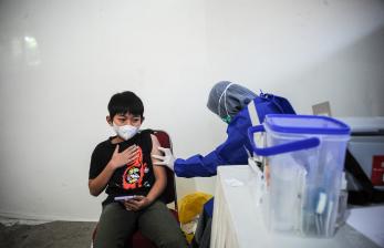 Tenaga kesehatan menyuntikkan vaksin COVID-19 kepada anak berusia 12 tahun saat vaksinasi massal. Dokter Agustina menyebutkan, beberapa tanda dan gejala Covid-19 pada anak-anak, diantaranya yaitu demam, sakit kepala, gejala saluran nafas seperti batuk, kehilangan rasa atau bau, sesak nafas, sakit tenggorokan, hidung tersumbat disertai pilek, nyeri otot, bisa juga berupa gejala saluran cerna seperti  mual atau muntah, diare, sakit perut, nafsu makan buruk, terutama pada bayi dibawah 1 tahun.