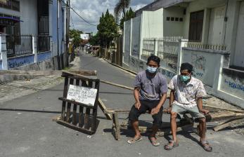 Warga berjaga di salah satu jalan akses menuju kawasan RW 04 Kampung Sambongpari, Kota Tasikmalaya, Jawa Barat, Senin (21/6/2021). Warga RW 04 di Kampung Sambongpari tersebut melakukan karantina wilayah mandiri menyusul 15 warganya terkonfirmasi positif COVID-19, satu di antaranya meninggal dunia usai berwisata ke Pangandaran.