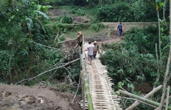 Warga melintas jembatan darurat di Desa Indrajaya, Kecamatan Sukaratu, Kabupaten Tasikmalaya, Senin (2/3). Jembatan utama yang berada di Desa Santanamekar, Kecamatan Cisayong, rusak terdampak longsor yang terjadi pada Jumat (28/2).