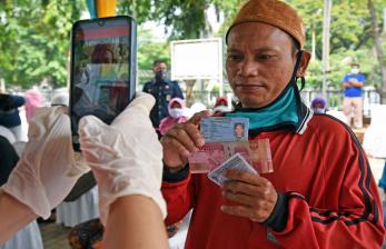 Warga penerima manfaat bantuan sosial tunai difoto petugas di Kantor Pos Serang, Banten, Rabu (6/5/2020). Bansos berupa uang tunai Rp600 ribu per KK per bulan diberikan kepada keluarga miskin dan rentan miskin dampak pandemi COVID-19 selama tiga bulan ke depan