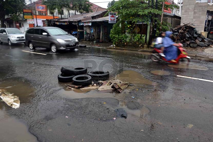  Tumpukan ban bekas disimpan di sebuah lubang akibat genangan air hujan di jalan PLN, Duren Tiga, Jakarta Selatan, Kamis (23/1).    (Republika/Agung Supriyanto)