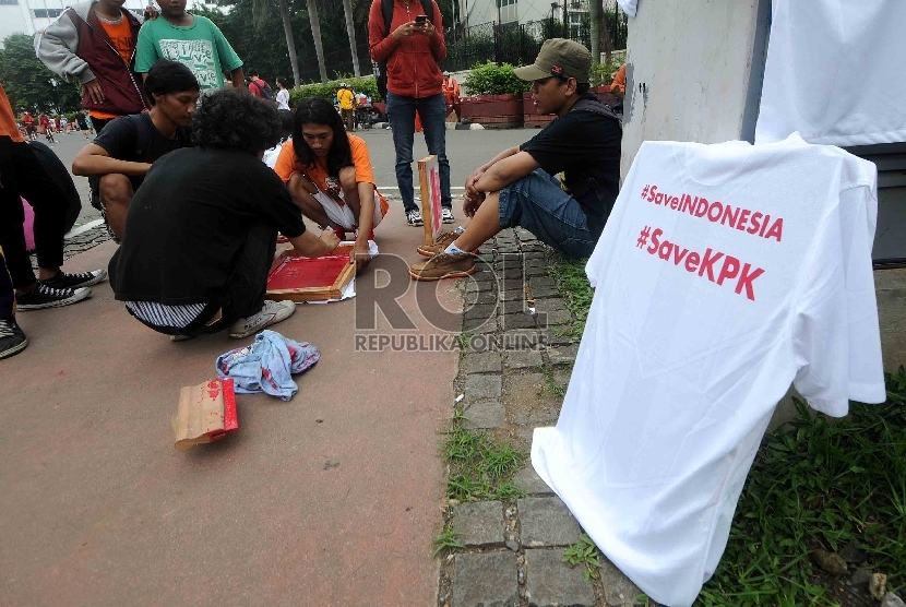 ?Pegiat anti korupsi memberikan layanan sablon kaos gratis anti korupsi kepada warga saat Hari Bebas Kendaraan Bermotor di Bundaran HI, Jakarta, Ahad (15/2).    (Republika/Agung Supriyanto)
