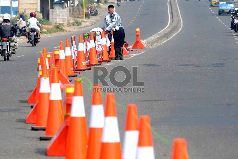 Petugas Dinas Perhubungan Lalu Lintas dan Angkutan Jalan Raya (Dishub LLAJ) memasang marka pembatas jalan di jalur mudik Cikampek, Jawa Barat, Ahad (12/7). (Republika/Agung Supriyanto)