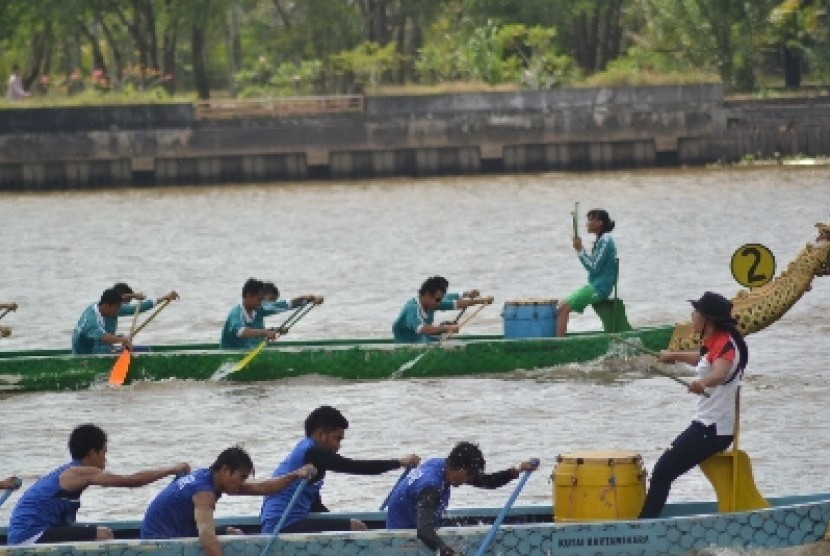 . Seorang pemandu terus memberi semangat anggota timnya untuk memukul bedug pada lomba perahu naga dalam Festival Erau Adat Pelas Benua Etam. 