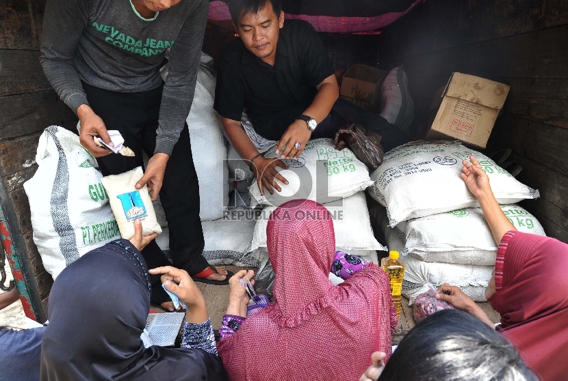 Warga mengantre saat membeli sembako pada truk operasi pasar di Pasar Rumput, Jakarta, Jumat (26/6).   (Republika/Tahta Aidilla)