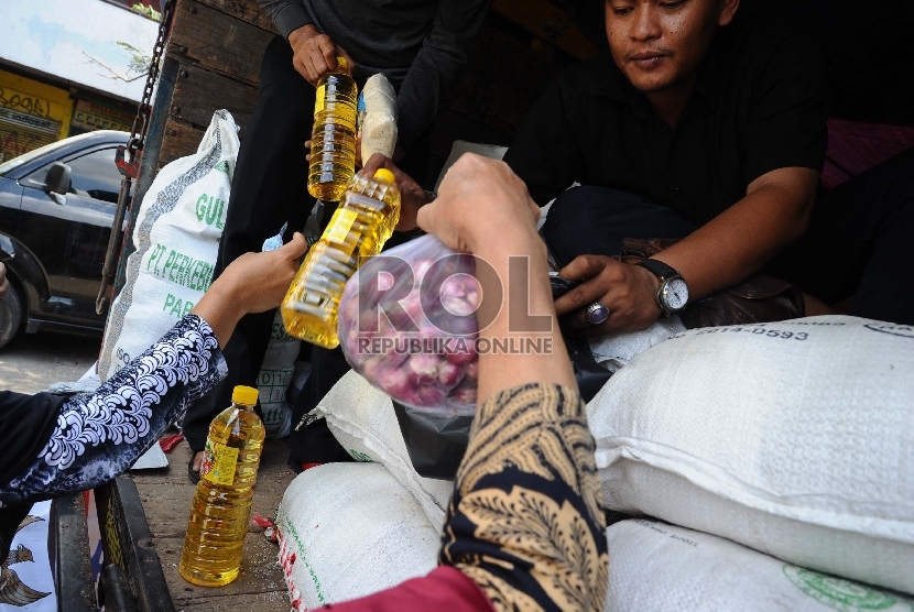 Warga mengantre saat membeli sembako pada truk operasi pasar di Pasar Rumput, Jakarta, Jumat (26/6).   (Republika/Tahta Aidilla)