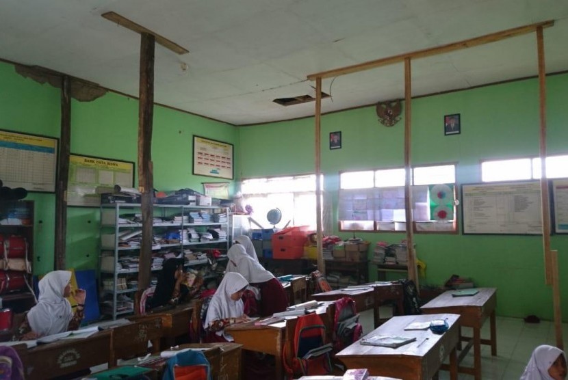  Ruangan tempat siswa belajar harus ditopang dengan enam batang kayu lantaran kondisi atapnya nyaris ambruk.