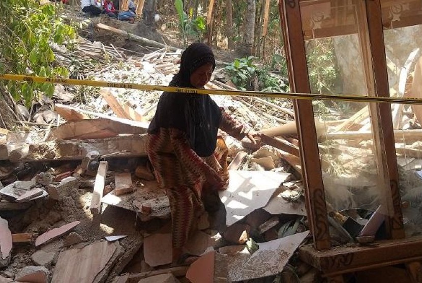  Korban hujan batu Dede Lia (26) tak kuasa menahan sedih melihat kondisi rumahnya yang hancur tertimpa batu berukuran besar