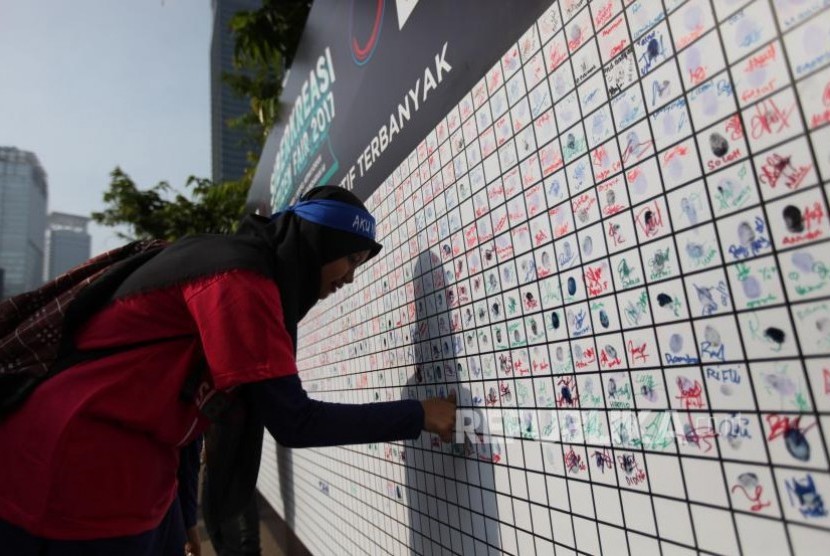 Seorang pelajar menandatangani dukungan deklarasi siberkreasi melawan hoax saat acara Siberkreasi Netizen Fair 2017 di kawasan CFD, Jalan Sudirman, Jakarta, Ahad (5/11).