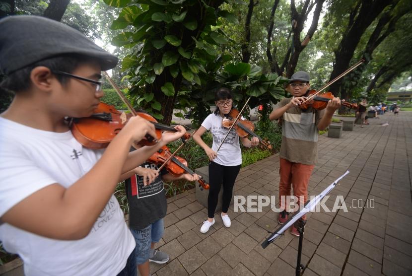 Siswa bermain musik biola di Taman Suropati, Jakarta.