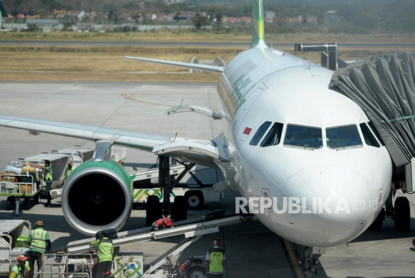 Petugas menurunkan bagasi milik penumpang pesawat di Bandara Internasional Ahmad Yani,Semarang,Jawa Tengah,Rabu (10/7).
