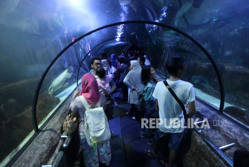Pengunjung melihat-lihat berbagai jenis ikan saat liburan di Seaworld Ancol, Jakarta, Jumat (30/3).