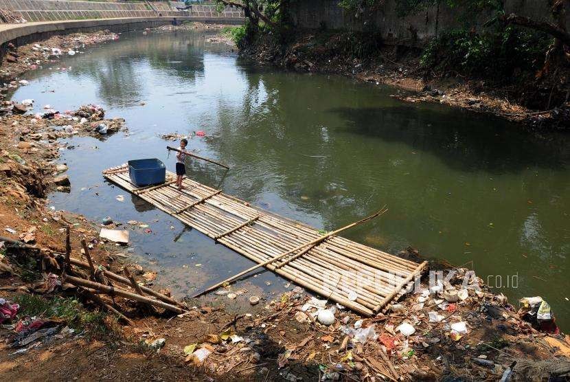 Anak-anak bermain di aliran Sungai Ciliwung yang tercemar oleh sampah di kawasan Kebon Baru, Tebet, Jakarta, Jumat (7/9).