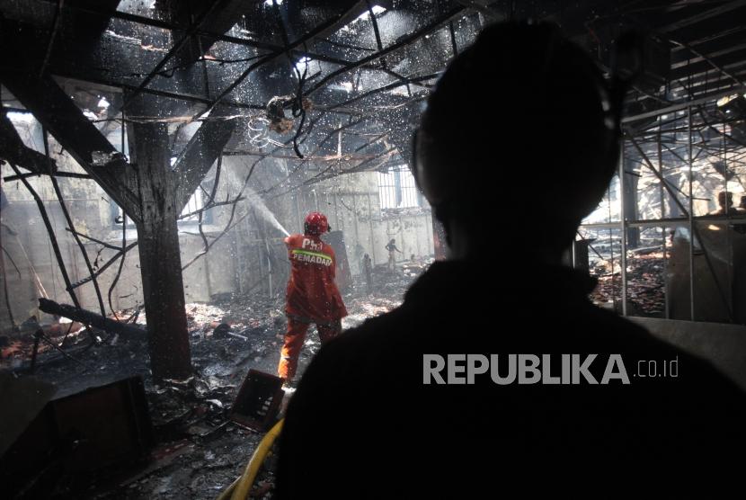 Petugas pemadam kebakaran berusaha memadamkan api yang membakar Museum Bahari di Penjaringan, Jakarta, Selasa (16/1).