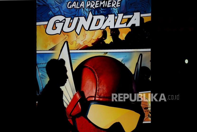 Undangan melintas di dekat neon box Gundala saat gala premiere  film Gundala di Epicentrum, Kuningan, Jakarta, Rabu (28/8).