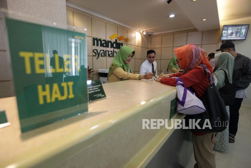 Petugas layanan nasabah melayani calon jamaah haji yang akan melakukan pelunasan Biaya Penyelenggaraan Ibadah Haji (BPIH) di Kantor Cabang Mandiri Syariah Area Bekasi, Jawa Barat, Selasa (19/3/2019).