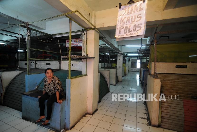Pedagang berdiam diri disamping kios-kios yang tutup di Blok G Pasar Tanah Abang, Jakarta Pusat, Jumat (17/11).