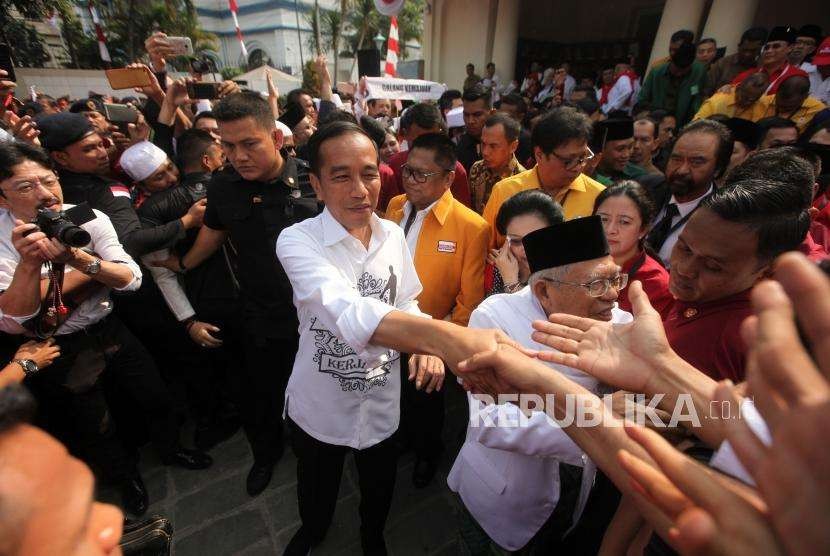 Calon presiden Joko Widodo (kiri) didampingi calon wakil presiden Ma'ruf Amin (kanan) bersalaman dengan para relawan seusai deklarasi di Gedung Joang, Jakarta, Jumat (10/8).