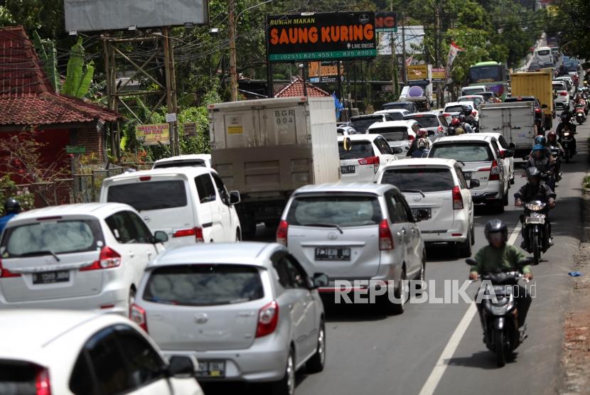 Antrean kendaraan saat penerapan satu arah (One way) di ruas Jalan Raya Puncak, Bogor, Jawa Barat, Sabtu (23/12).