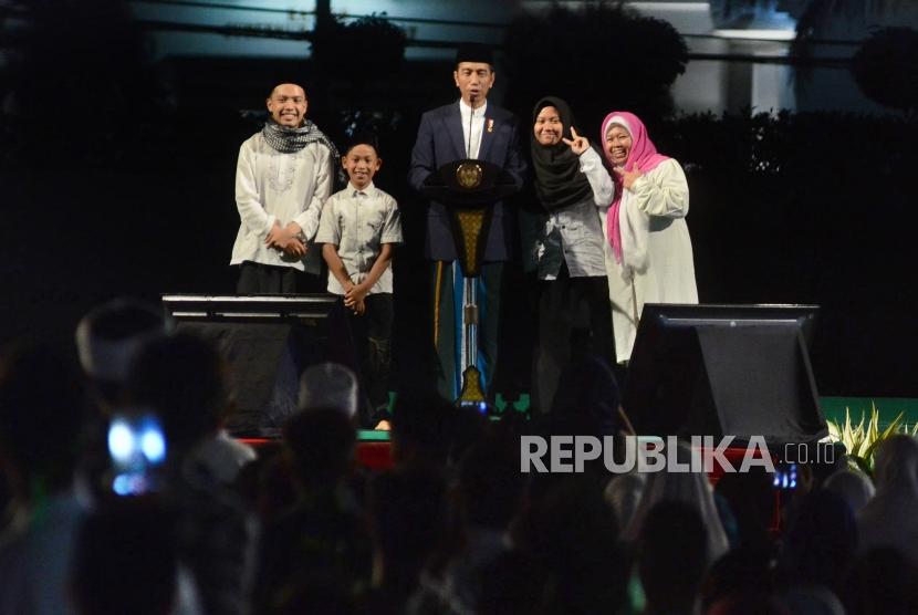 Didampingi sejumlah santri, Presiden RI Joko Widodo (Jokowi) berdialog dengan para santri saat menghadiri malam puncak peringatan Hari Santri Nusantara, di Lapangan Gasibu, Kota Bandung, Ahad (21/10).