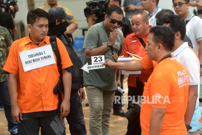 Sejumlah petugas kepolisian bersama tersangka saat reka ulang adegan kasus peluru nyasar di Lapangan Tembak, Senayan, Jakarta Selatan, Jumat (19/10).