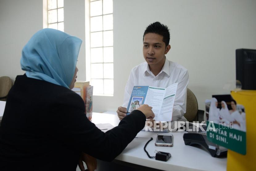 Petugas melayani nasabah di salah satu kantor Bank Danamon Syariah di Jakarta, Selasa (16/10).