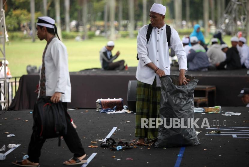 Peserta reuni aksi 212 mengumpulkan sampah seusai Reuni Aksi 212 di Lapangan Monumen Nasional, Jakarta, Ahad, (2/12).