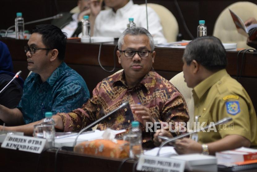 Ketua KPU Arief Budiman (tengah) berbincang dengan Staf Ahli Bidang Pemerintahan Kemendagri Suhajar Diantoro (kanan) saat mengikuti Rapat Dengar Pendapat (RDP) dengan Komisi II DPR di Kompleks Parlemen Senayan, Jakarta, Selasa (13/3).